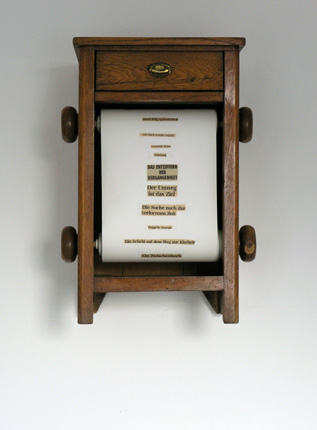1997, "mixed diary III", Papierrolle mit aufgeklebten Zeitungsausschnitten (Länge ca. 33 Meter), Holz, Blech, 70,5 x 48 x 40 cm